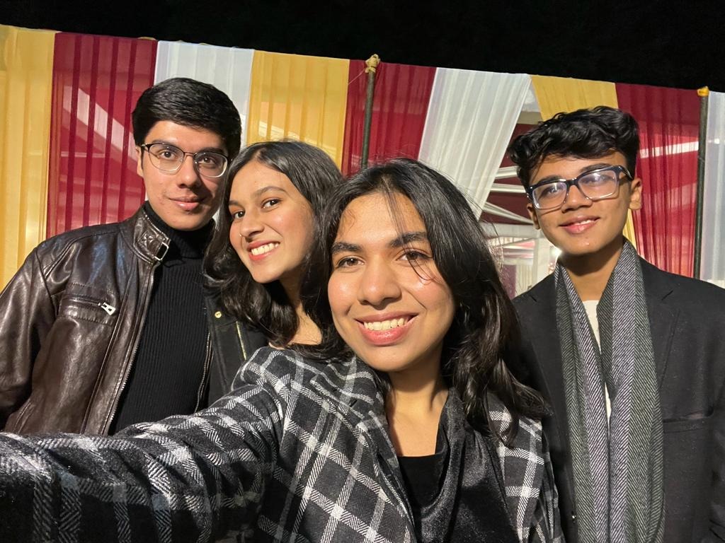 Aarushi taking a night-time selfie with three of her cousins, all dressed up and smiling.